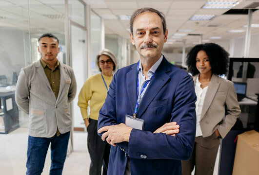 Confident manager and diverse business team standing in the office