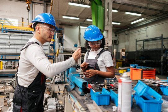 Mechanic and engineer discussing production in an industrial workshop