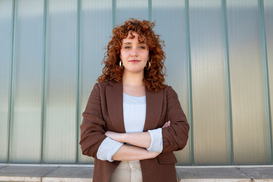 Confident businesswoman with arms crossed standing outdoors