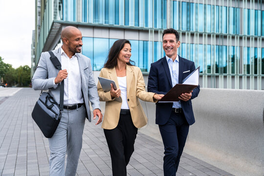 Business team walking and discussing in financial district