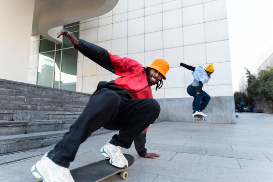 Friends skateboarding together on urban street in El Raval Barcelona