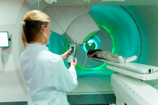 Doctor operating proton therapy equipment for cancer treatment in a hospital setting