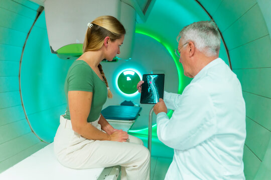 Doctor showing spine scan to patient in radiology room