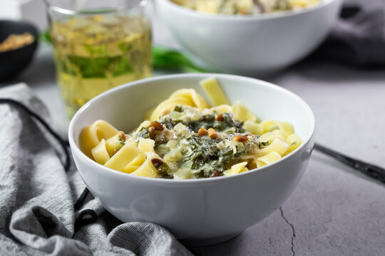 Bowl of creamy wild garlic tagliatelle pasta with pine nuts