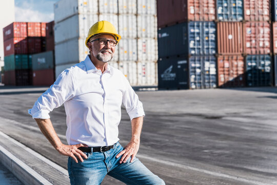 Confident logistic manager in hard hat at container terminal