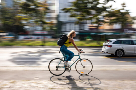 Woman cycling rapidly along urban street in daytime