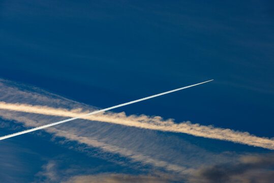Airplane contrails crossing each other in a clear blue sky