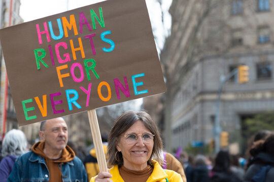 Activist holding human rights for everyone sign at a city rally