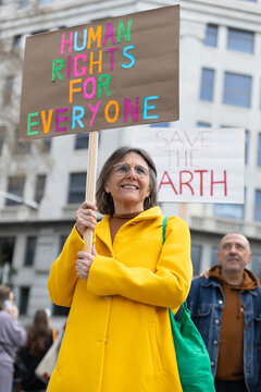 Smiling activist holding human rights sign at Barcelona protest