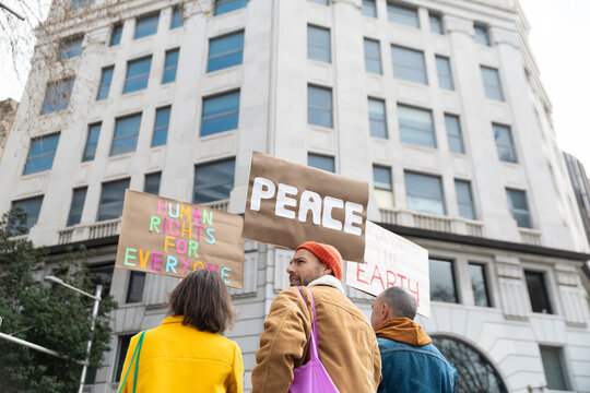 Activists holding peace and human rights protest signs outdoors