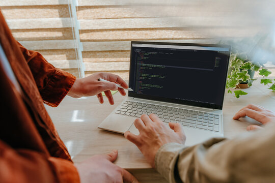 Team reviewing software code on a laptop in the office