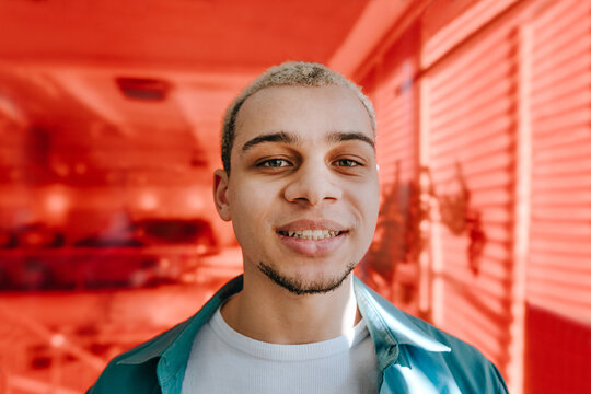 Smiling businessman looking at camera in a red office indoors