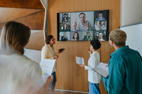Business colleagues discussing presentation on video call in office