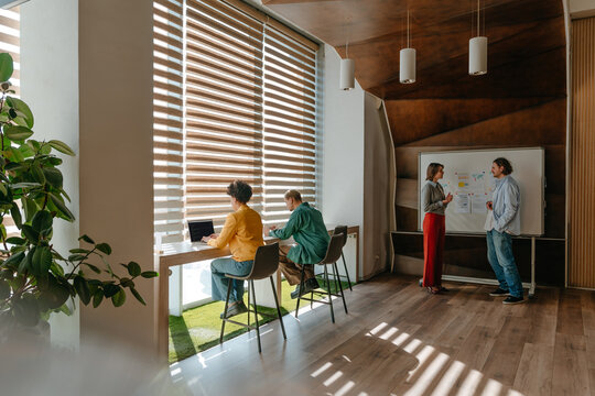 Colleagues working and brainstorming in modern office