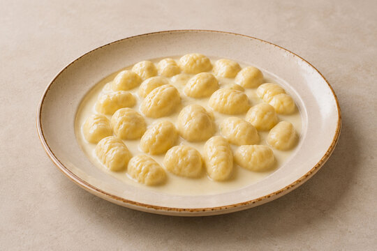 Italian Gnocchi alla Bava with Melted Fontina Cheese on Neutral Background