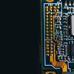 Fototapeta premium Macro of a printed circuit board with gold traces and electronic components representing modern technology and engineering