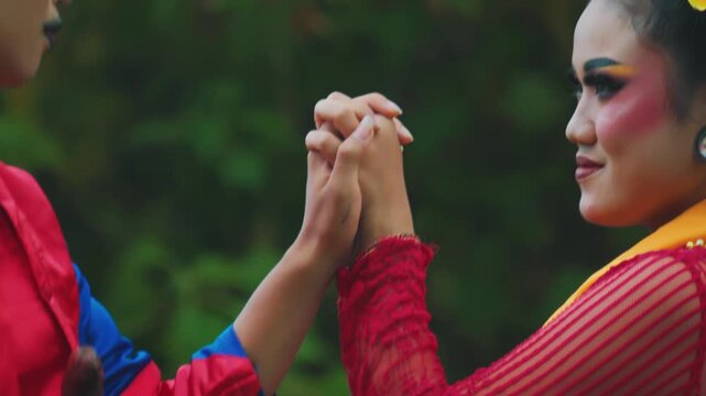 Close-Up of Intertwining Hands and Intimate Gaze of Indonesian Dancers