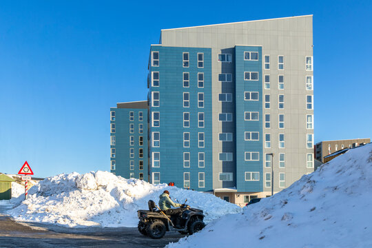 Modern Inuit apartment building with a quad bike on a snowy urban road, Nuuk, Sermersooq, Greenland