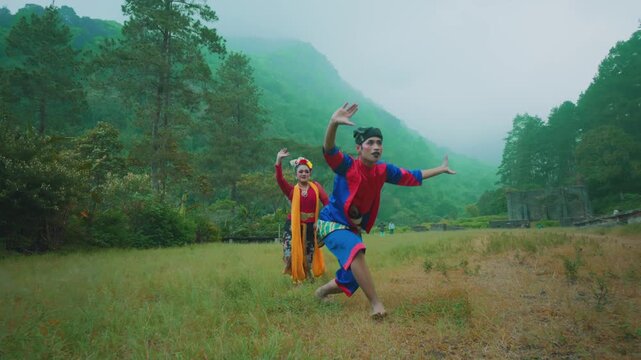 Traditional Indonesian Dancers Performing with Energy on a Misty Hillside