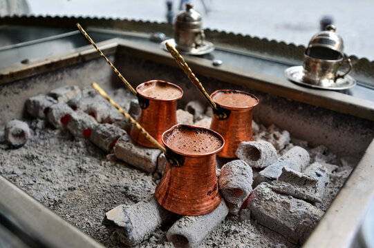 Traditional Turkish coffee cezve brewing on hot coals