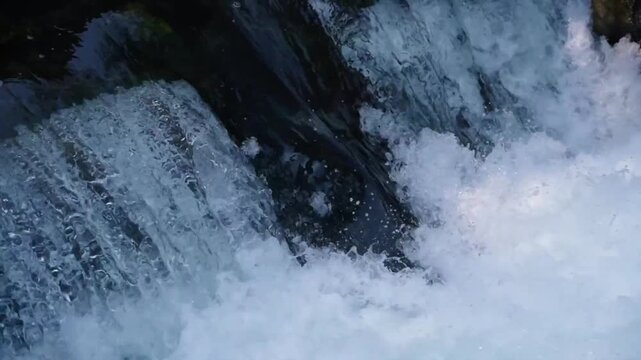 Close up view of rushing waterfall with white foam and clear water