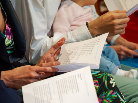 Famille suivant la liturgie lors d&rsquo;un bapt&ecirc;me dans une &eacute;glise