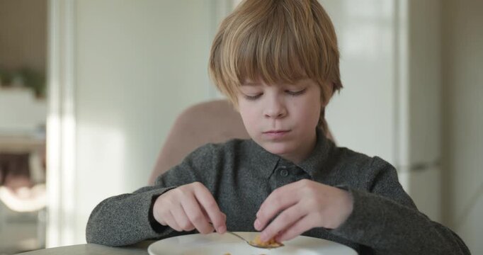 Kid Boy Eats Corn Flakes Meal in Kitchen. 4K 10-bit