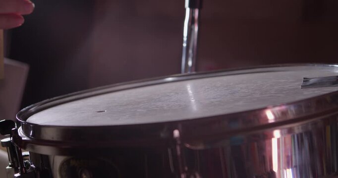 Drummer playing on concert and hit the snare drum, close up in studio
