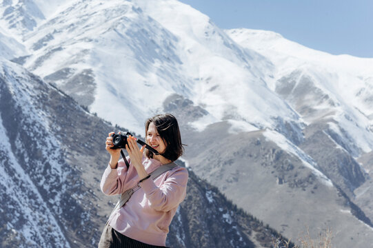 Photographer taking pictures of snowy mountains on vacation