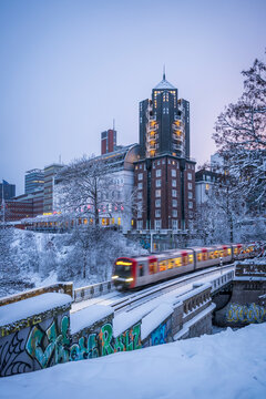 Subway train passing Stintfang hotel in snowy Hamburg at dusk