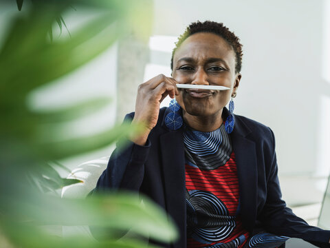 Playful businesswoman with digitized pen on lips at office