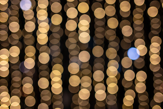 Abstract blurred background of glowing yellow bokeh string lights