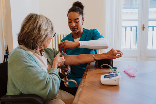 Nurse measuring blood pressure during in-home healthcare visit