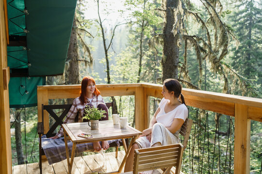 Friends relaxing and talking on a glamping terrace in Siberia