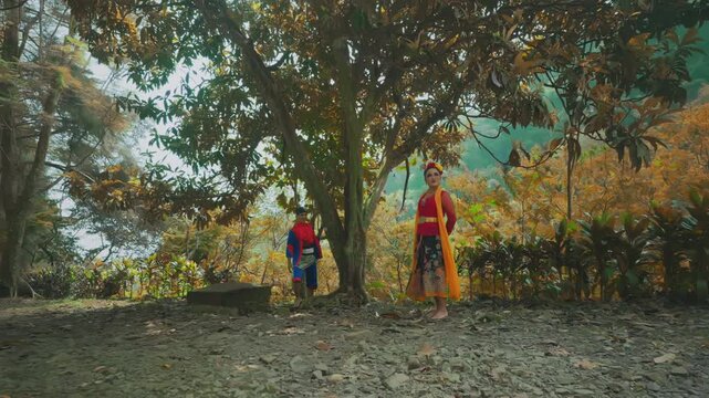 Traditional Dancer Searching Behind Large Tree