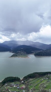 Bicaz Lake aerial view with exposed sandy shore and village