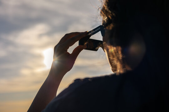 Person using solar eclipse glasses for safe total or annular solar observation, watching celestial event