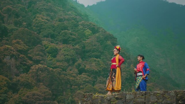 Cultural Couple Posing on Stone Wall Overlooking Jungle Valley