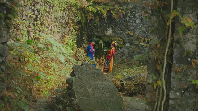 Couple in Traditional Attire Talking in Ancient Stone Ruins