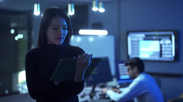female software developer using a tablet working in a modern office.