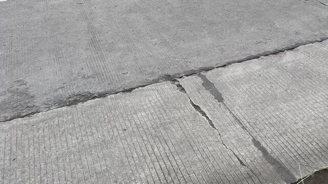 Close up of cracked concrete road surface texture