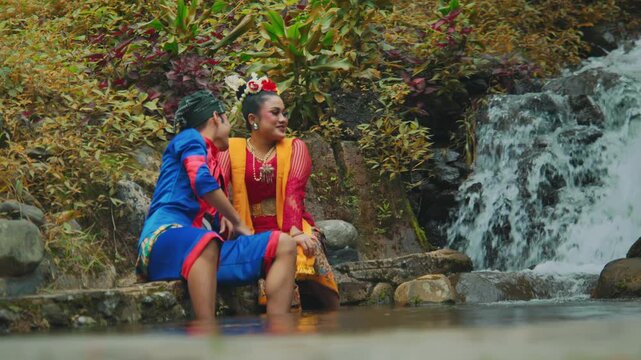 Playful Couple Splashing Water with Feet in River Stream