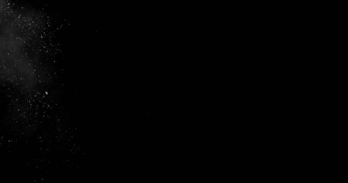 Super slow motion blizzard snow particles flying across a black background. Intense winter storm SFX overlay with chaotic flakes, windblown debris and cinematic atmospheric texture.