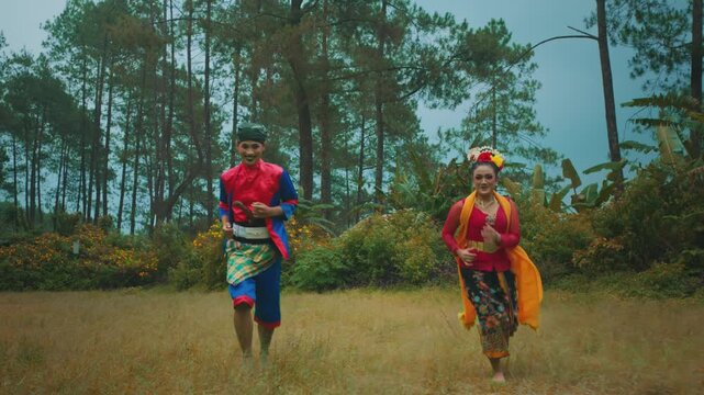 Happy Indonesian Couple in Traditional Costume Running in Nature