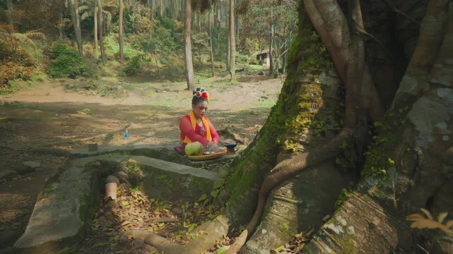 Javanese Woman Lighting Incense for Forest Offering Ritual