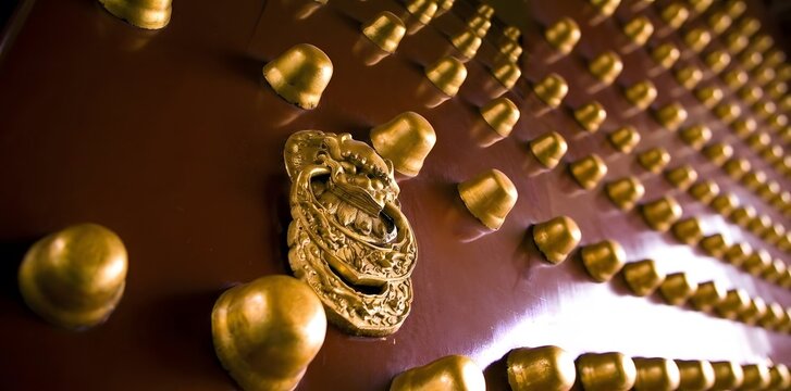 Traditional oriental golden door decorated with round studs