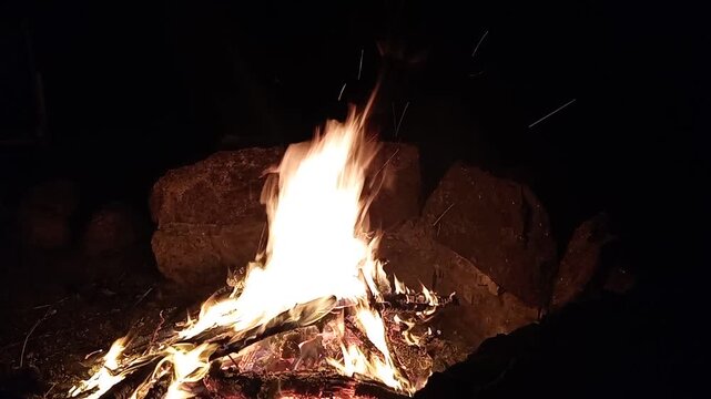 Fire, a bonfire with hot flames rising upwards. A dark night as a background