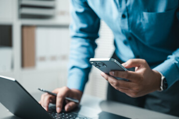 Fototapeta premium Business professional using smartphone and laptop for online communication, fintech, and digital lifestyle activities.