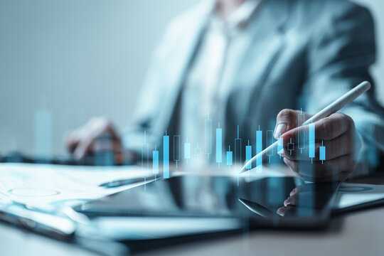 Business professional using stylus on tablet with stock candlestick chart overlay, representing investment analysis, portfolio management, market trends, and financial strategy.