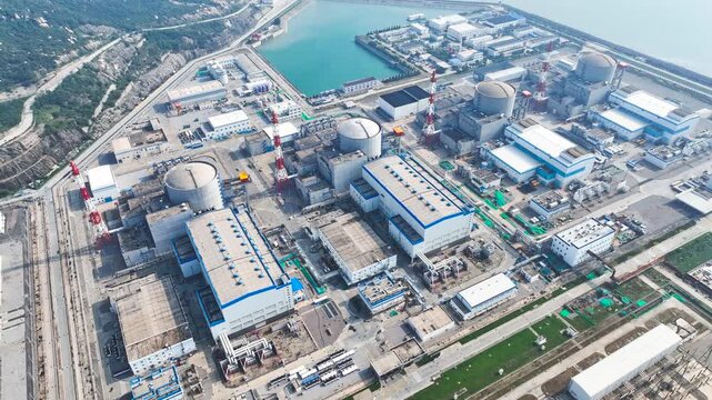 Coastal nuclear power plant with reactor domes and industrial buildings